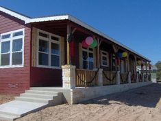 a red house with balloons on the front porch and steps leading up to it's second story