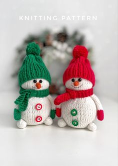 two knitted snowmen sitting next to each other on top of a white table