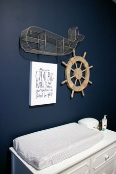 there is a baby crib in the room with a boat and ship wheel on the wall