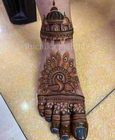 the foot is decorated with henna and peacocks