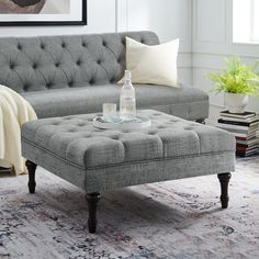 a living room with a gray couch and ottoman