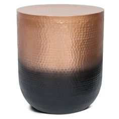 a black and gold vase sitting on top of a white table