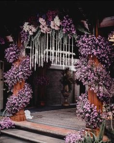 an outdoor wedding ceremony with purple flowers and greenery on the altar, surrounded by wooden pillars