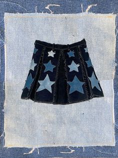 -made to order- 100% deep-navy denim with a hand-sewn/treated denim star design, perfect for the diva that knows 'these are my legs and they're ready for prime-time'. each 'box pleat' is framed with a distressed navy-blue patchwork and three distressed stars. this garment is built to fray and get even better after multiple wears. zipper in back with waistband snap. length: '14-'15 see FAQ for size chart all pieces sewn by me made-to-order items ship within 1-2 weeks. Denim Stars, Denim Pleated Skirt, The Diva, Get Even, Prime Time, Star Design, Box Pleats, Star Designs, Star Shape