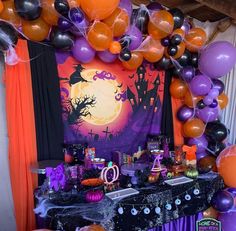 an outdoor halloween party with balloons, decorations and table cloths on the outside wall