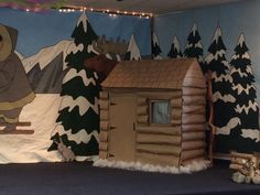 there is a fake log cabin with a bear on the roof and snow on the ground