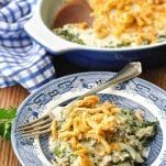 two plates filled with macaroni and cheese casserole on a wooden table