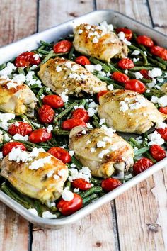 chicken, green beans and tomatoes with feta cheese in a casserole dish