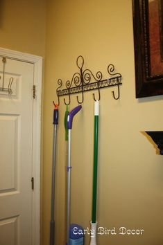 two brooms are hanging on the wall next to a door