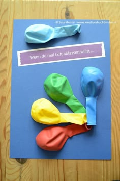 three different colored plastic spoons sitting on top of a piece of paper