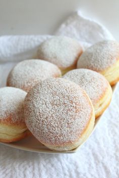 powdered sugar covered donuts on a white plate