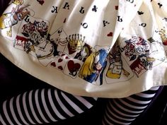 there is a skirt with pictures on it and black and white striped tights in front of her