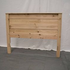 a wooden bed frame with no headboard or foot board is shown in front of a white wall