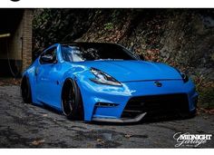 a blue sports car parked in front of a building