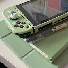 a nintendo wii game system sitting on top of a green table next to a pen