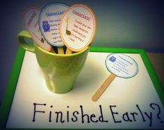 a cup filled with paper and wooden spoons sitting on top of a sign that says finished early