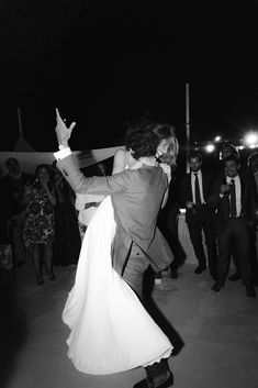 a bride and groom dance together at their wedding reception in front of an audience on the dance floor