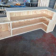 a wooden bench sitting on top of a hard wood floor next to a pile of pallets