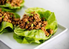 lettuce wraps filled with ground meat on a white platter, ready to be eaten