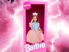 a barbie doll in a pink box with lightning behind her and the name barbie written on it