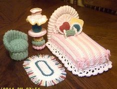 a crocheted baby's blanket, booties and diaper on a table