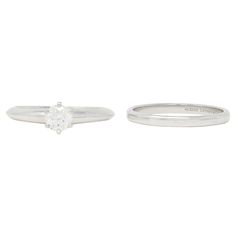 two white gold and diamond rings, one with a single stone in the center on each side