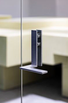 an electronic device is attached to a pole in the middle of a room with white walls