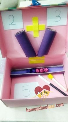 a pink box with scissors and other items in it