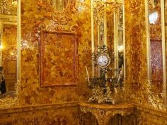 an ornately decorated room with gold walls and mirrors on either side of the wall