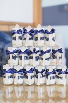 a stack of baby bottle cakes with blue ribbons on them sitting on top of a table