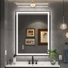 a bathroom sink with a mirror above it and lights on the wall next to it