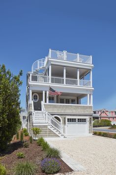 a large white house with stairs leading up to the second floor and two story balconies