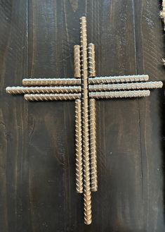 a cross made out of nails sitting on top of a wooden table