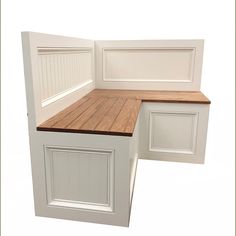 a corner kitchen bench made out of wood and white cabinets