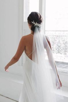 the back of a bride's dress, with her veil draped over her shoulder