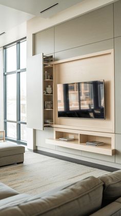 a living room with couches and a flat screen tv mounted to the side of a wall