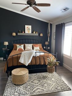 a bed room with a neatly made bed and a ceiling fan