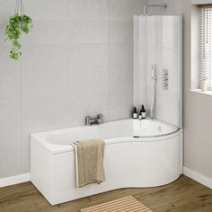 a white bath tub sitting on top of a wooden floor