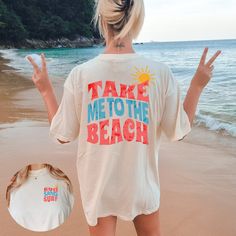 "Crafted from soft and breathable Comfort Colors fabric, this oversized t-shirt offers a relaxed fit and a lived-in feel. Its loose and casual design makes it ideal for beach outings, summer adventures, or simply lounging by the shore. Featuring graphics on both the front and back, this t-shirt proudly displays the phrase \"Take Me to the Beach\". The coastal-inspired design captures the essence of beach life and invokes a sense of relaxation and wanderlust. Whether you're planning a beach getaway, reminiscing about past beach vacations, or simply dreaming of the ocean, this t-shirt is the perfect companion. Its oversized style allows for easy layering or wearing on its own, making it a versatile addition to your summer wardrobe. Share your love for the beach and let your free-spirited nat Beach T Shirt Outfit, Funny Print T-shirt For Beach Vacation, Bohemian Short Sleeve Beach T-shirt, Oversized Bohemian Summer T-shirt, Oversized Bohemian T-shirt For Summer, Bohemian Short Sleeve Tops For Beach Party, White Beachy T-shirt For Beach Party, Relaxed Fit Top For Beach Cover-up, Relaxed Fit Tops For Beach Season Cover-up