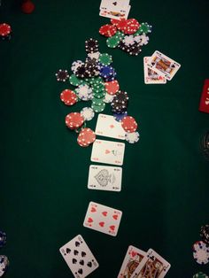 poker chips and playing cards on a green table