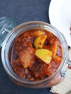 a glass jar filled with food sitting on top of a table next to a plate