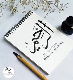 a notebook with an arabic calligraphy on it next to a fountain pen