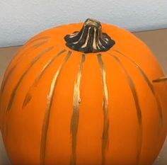 an orange painted pumpkin sitting on top of a table