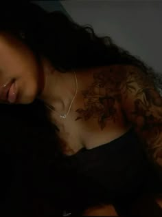 a woman with tattoos on her chest and arm