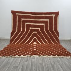 an area rug is on the floor in front of a white wall