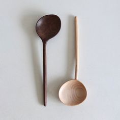 two wooden spoons and a wooden spoon on a white surface