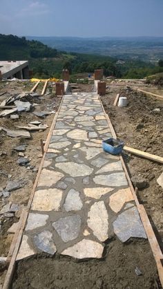 a stone walkway being built in the middle of a field