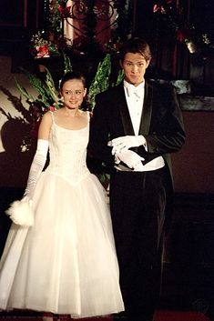 a young man and woman dressed in formal wear