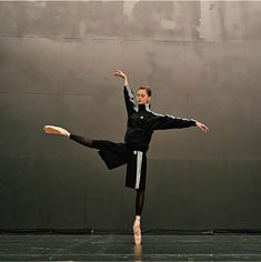 a man in black and white is doing a dance move with his legs spread out