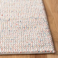 a white rug with multicolored dots on it